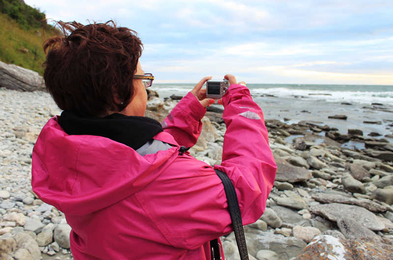 Person fotograferar havet med digitalkamera.